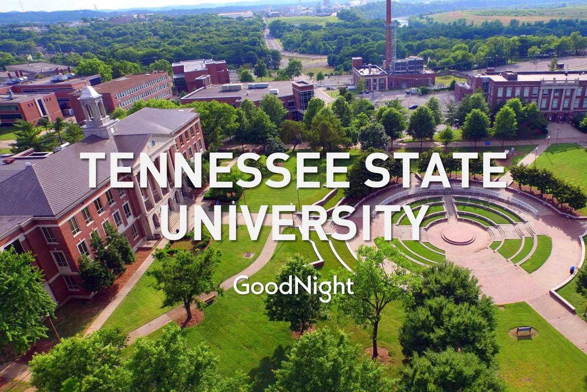 A university building framed by a circular fountain, lush green lawns, and walking paths—a vibrant outdoor community space. The open lawns and paths suggest ample room for families to stroll, play, and unwind together.