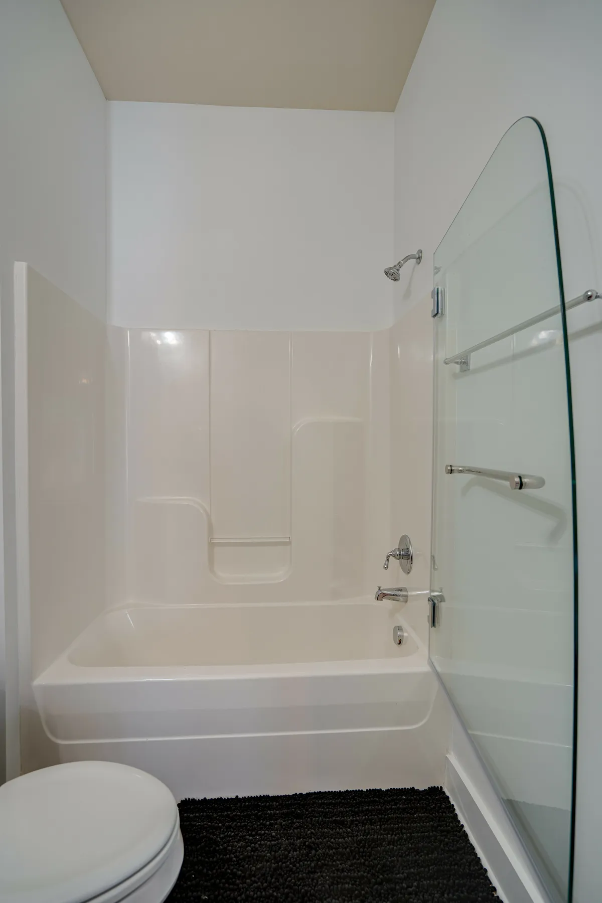 A spa-inspired bathroom featuring a sleek bathtub, glass shower door, and modern sink. The setting is designed for relaxation, self-care, and calm, with clean lines and soothing decor that evoke a spa-like experience.